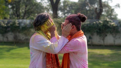 Woman in Pink Long Sleeve Shirt Standing and Covering Her Face With Her Hands