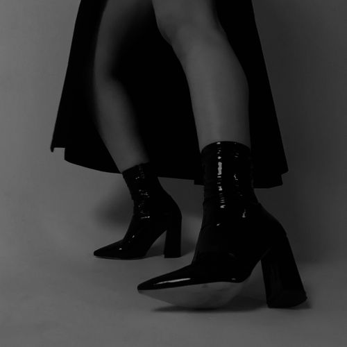 Free Stylish black high heel boots showcased in a minimalist monochrome setting. Stock Photo