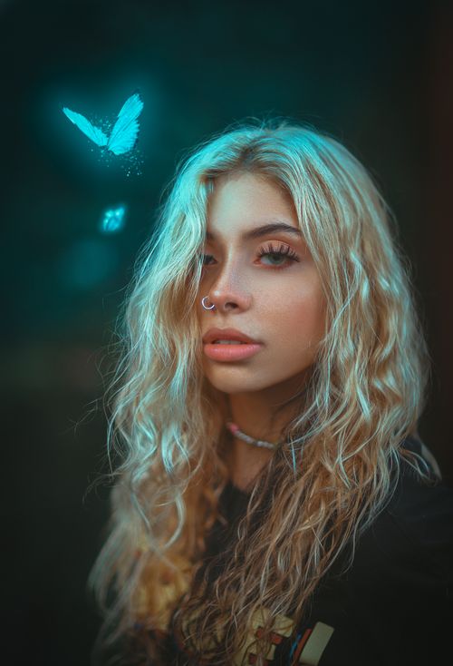 Free Portrait of a woman with glowing butterfly, depicting ethereal beauty and magical atmosphere. Stock Photo