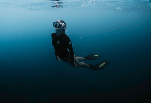 Free A swimmer in a scuba mask and fins immersed in the deep blue sea. Stock Photo