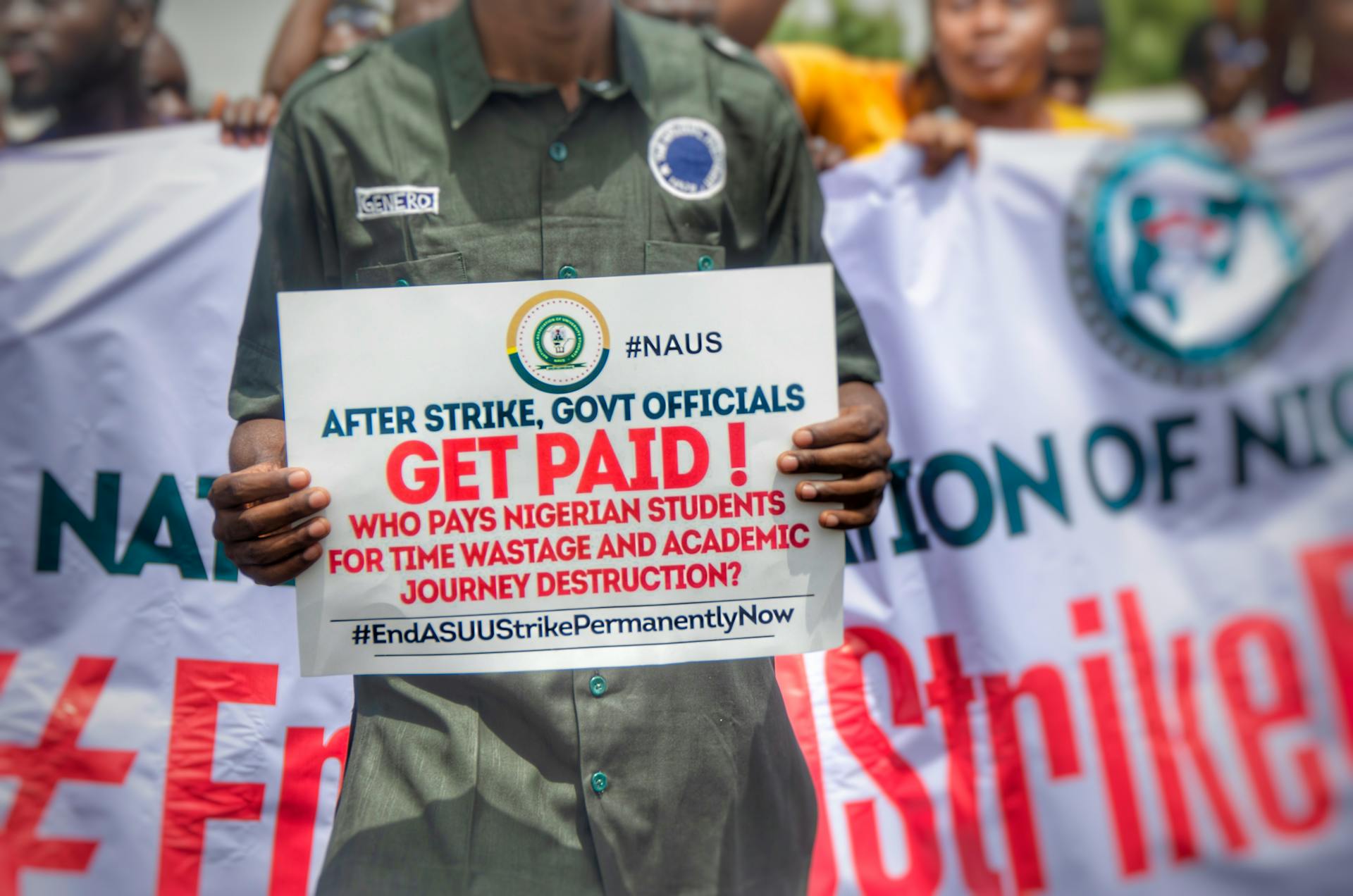 Nigerian students protest against government policies affecting education with visible signs and banners.