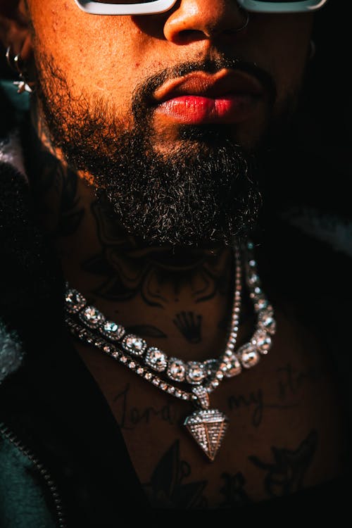 A Close-up Shot of a Bearded Man Wearing Silver Necklaces