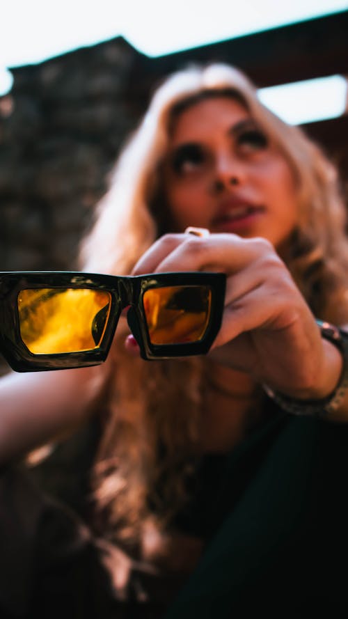 Blonde Woman Holding Black Framed Sunglasses