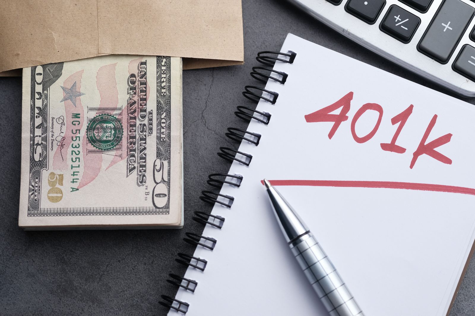 Savings planning setup with notebook, cash and calculator