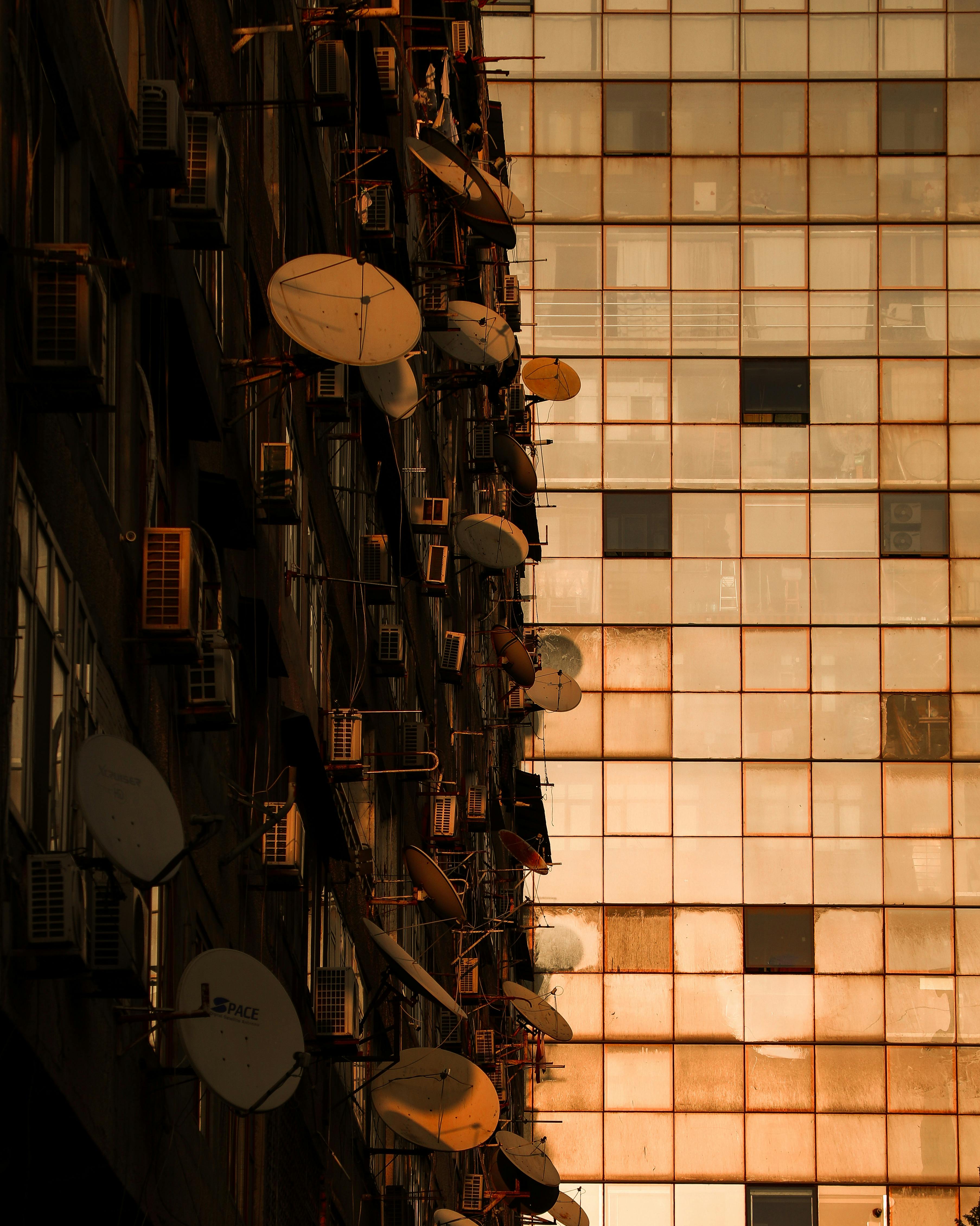 Urban architecture with satellite dishes on a high-rise building facade in Baku, Azerbaijan.
