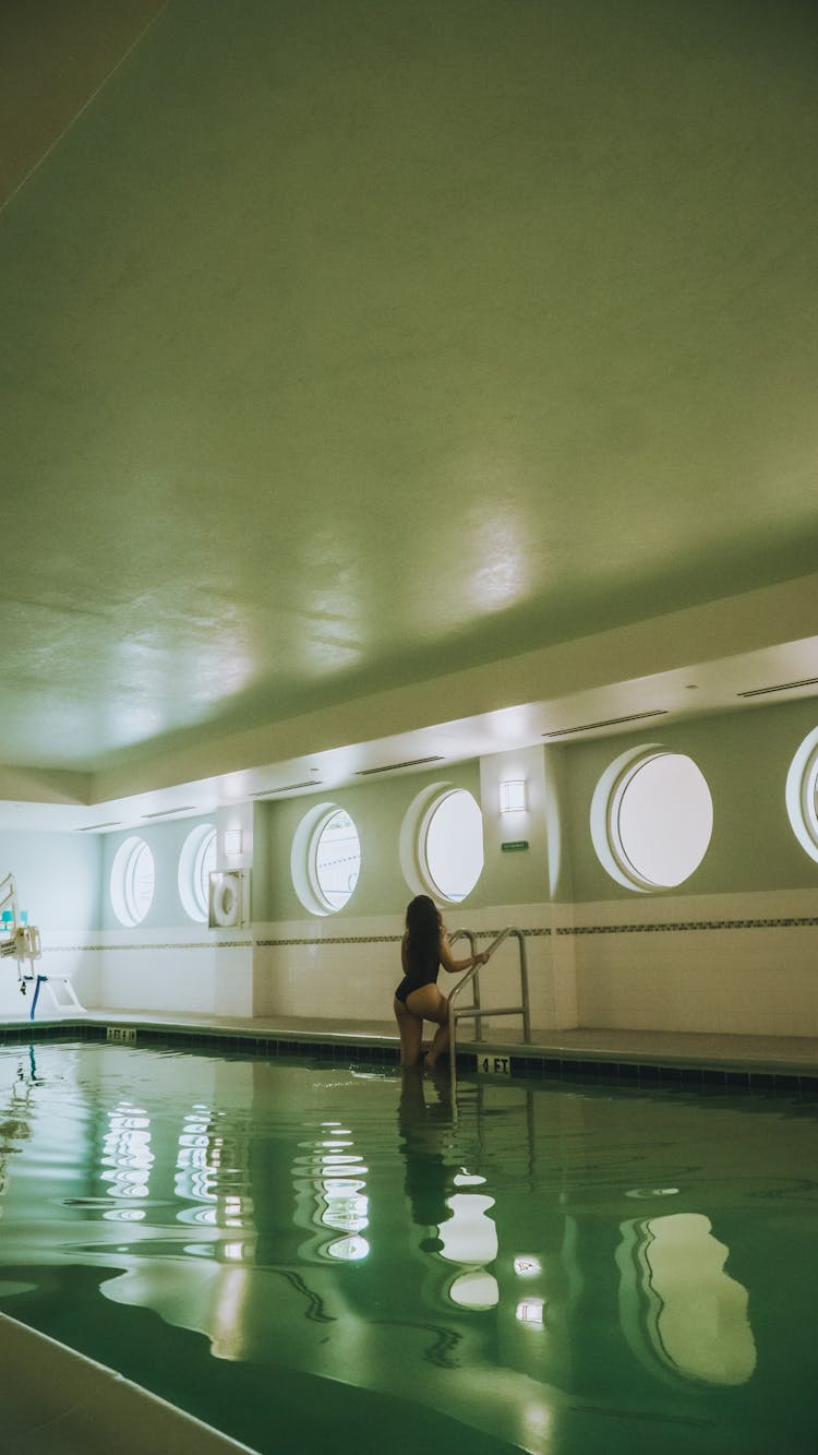 Woman Getting Out Of Indoor Pool