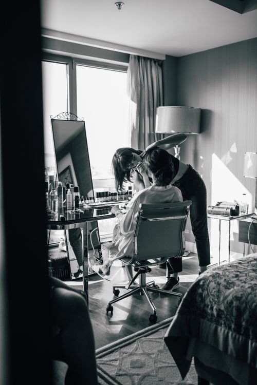 Free Bride getting makeup done in a hotel room, black and white style. Stock Photo