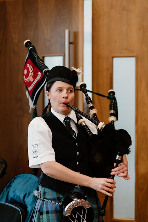 Female Piper in National Scottish Outfit Playing Bagpipes