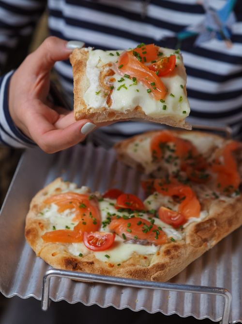 Free Gourmet pizza slice with cheese, tomatoes, and herbs served on a metal tray. Perfect for food lovers. Stock Photo