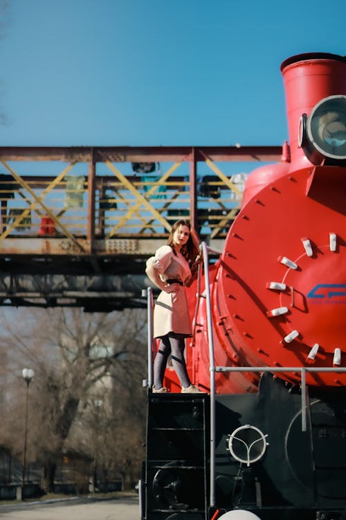 A Woman Standing next to a Locomotive