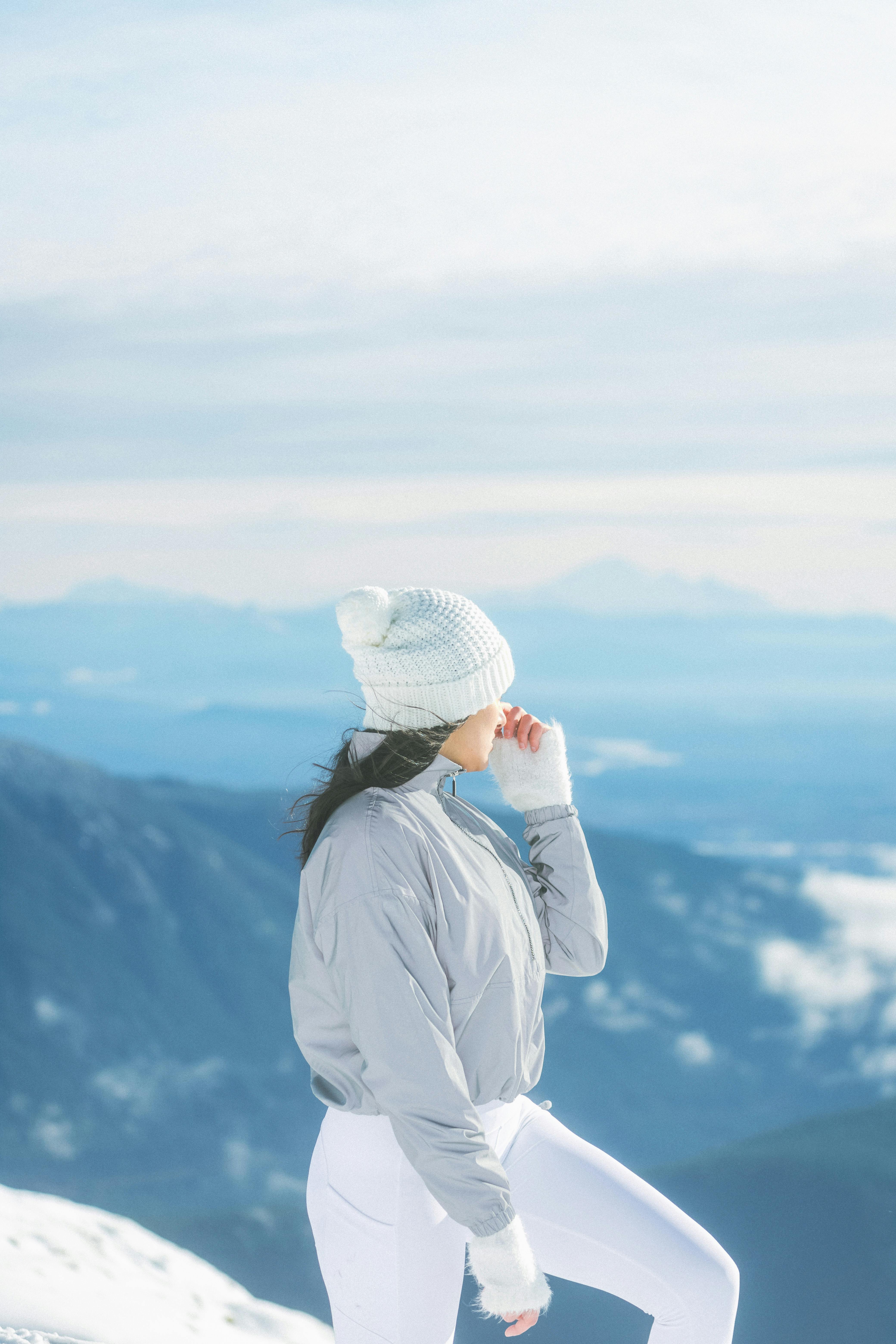 Woman in winter clothing admiring scenic mountain view in British Columbia, Canada.