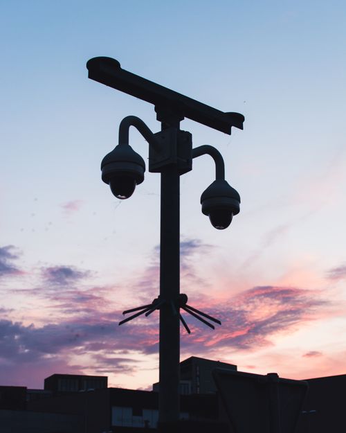 Free Silhouette of security cameras against a vibrant sunset sky, showcasing modern surveillance technology. Stock Photo