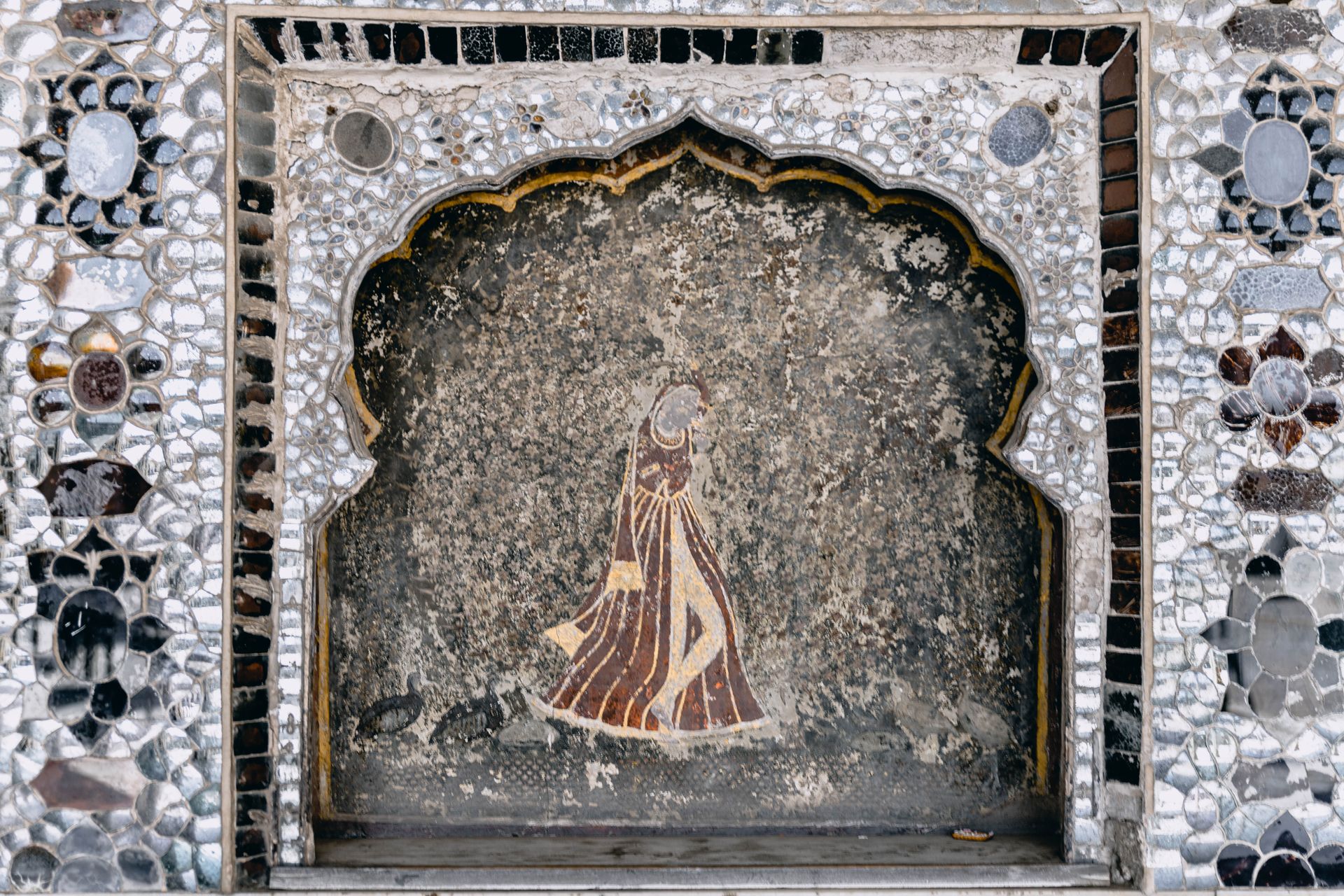 Mosaic artwork featuring a traditional figure set in an ornate frame at Lahore Fort.