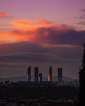 Capture of Madrid's skyline with skyscrapers silhouetted against a vibrant sunset sky.