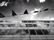 现代玻璃建筑的低角度视图映衬出戏剧性的天空与云