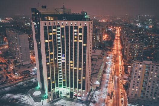 Aerial view of an illuminated city skyline in Ukraine at night, showcasing vibrant city lights.
