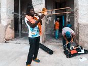 Man in Blue and T-shirt Playing Trumpet