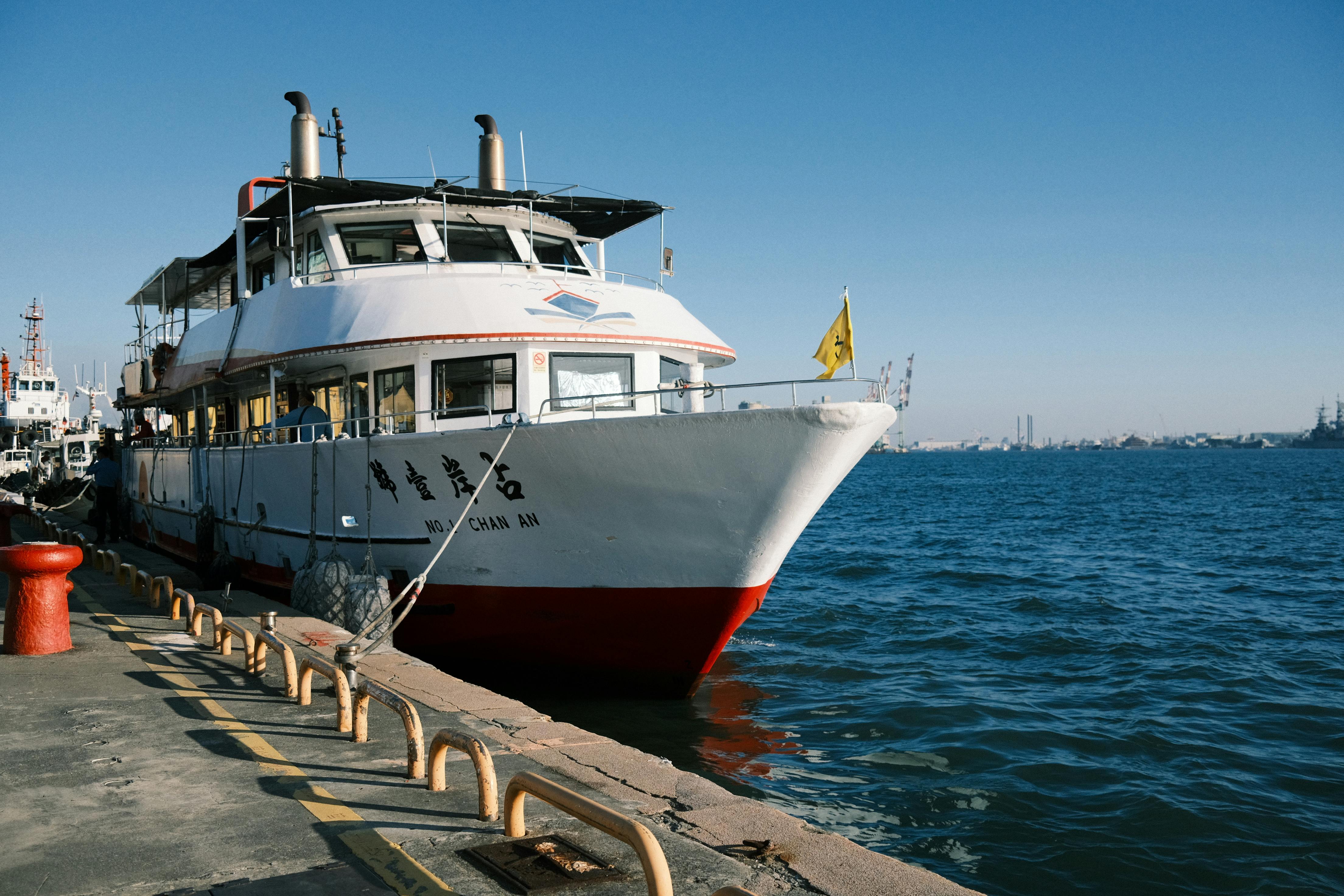 A passenger ferry docked at Kaohsiung Harbor, Taiwan, under a clear blue sky