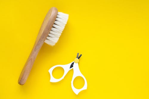 Free Wooden Brush and Scissors in Yellow Surface  Stock Photo