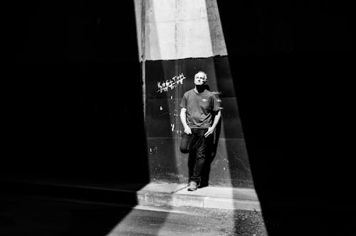 Monochrome Photo of an Elderly Man Leaning on a Wall 