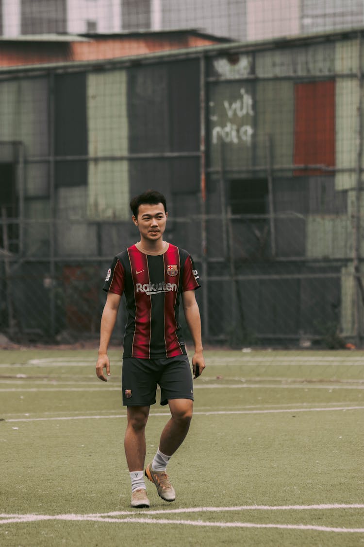 Man In Red And Black Jersey Shirt Standing On A Field