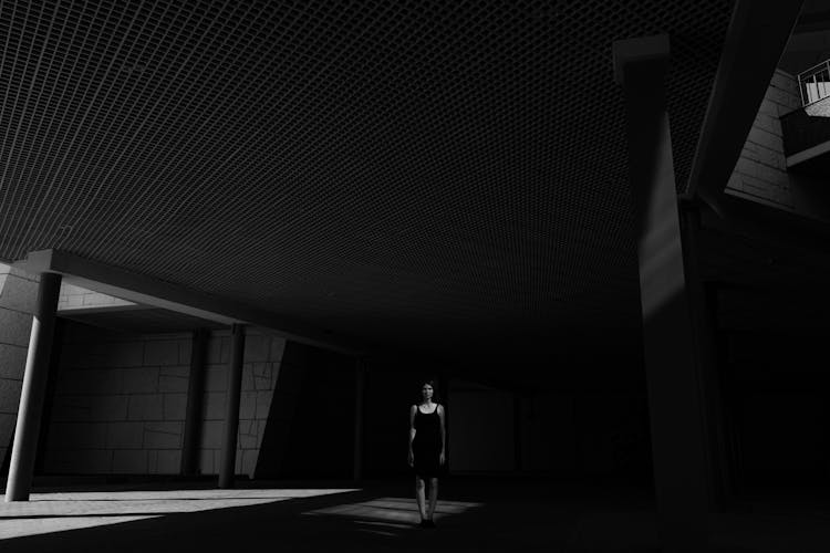 A Woman Walking On A Dark Hallway