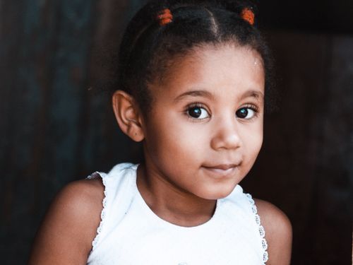 Free Charming portrait of a young girl with a blurred background, expressing innocence and warmth. Stock Photo