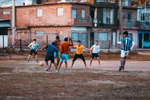 Free Group of teenagers playing a casual soccer game in an urban neighborhood setting. Stock Photo