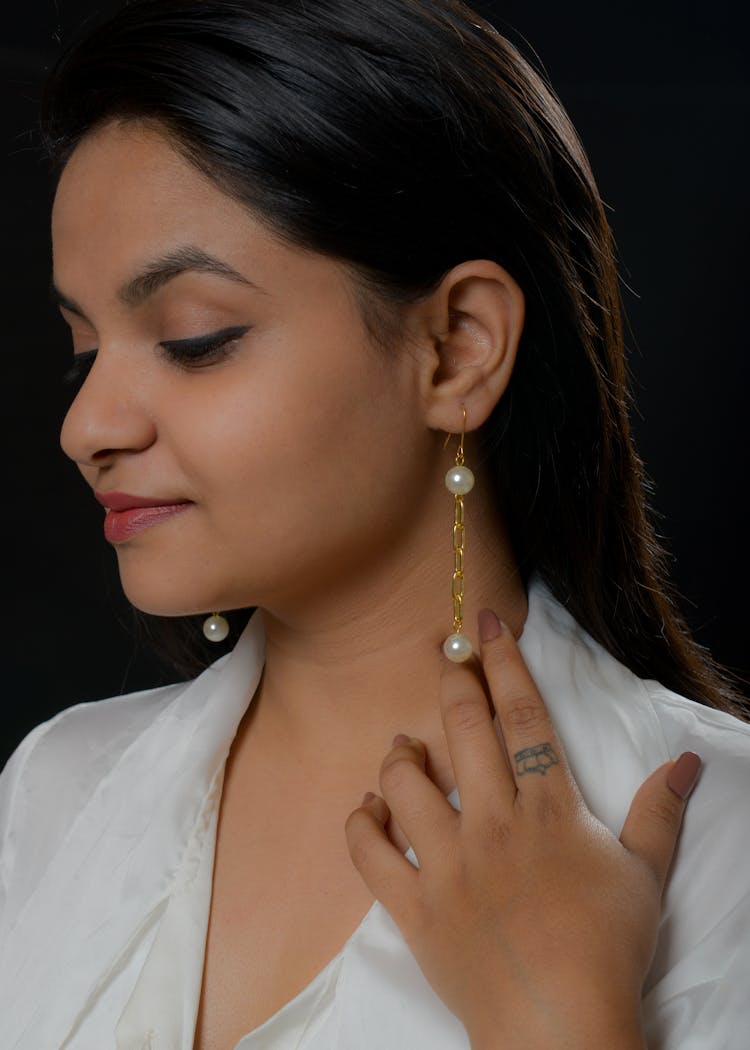 Woman In White Shirt Wearing A Gold With Pearl Earrings