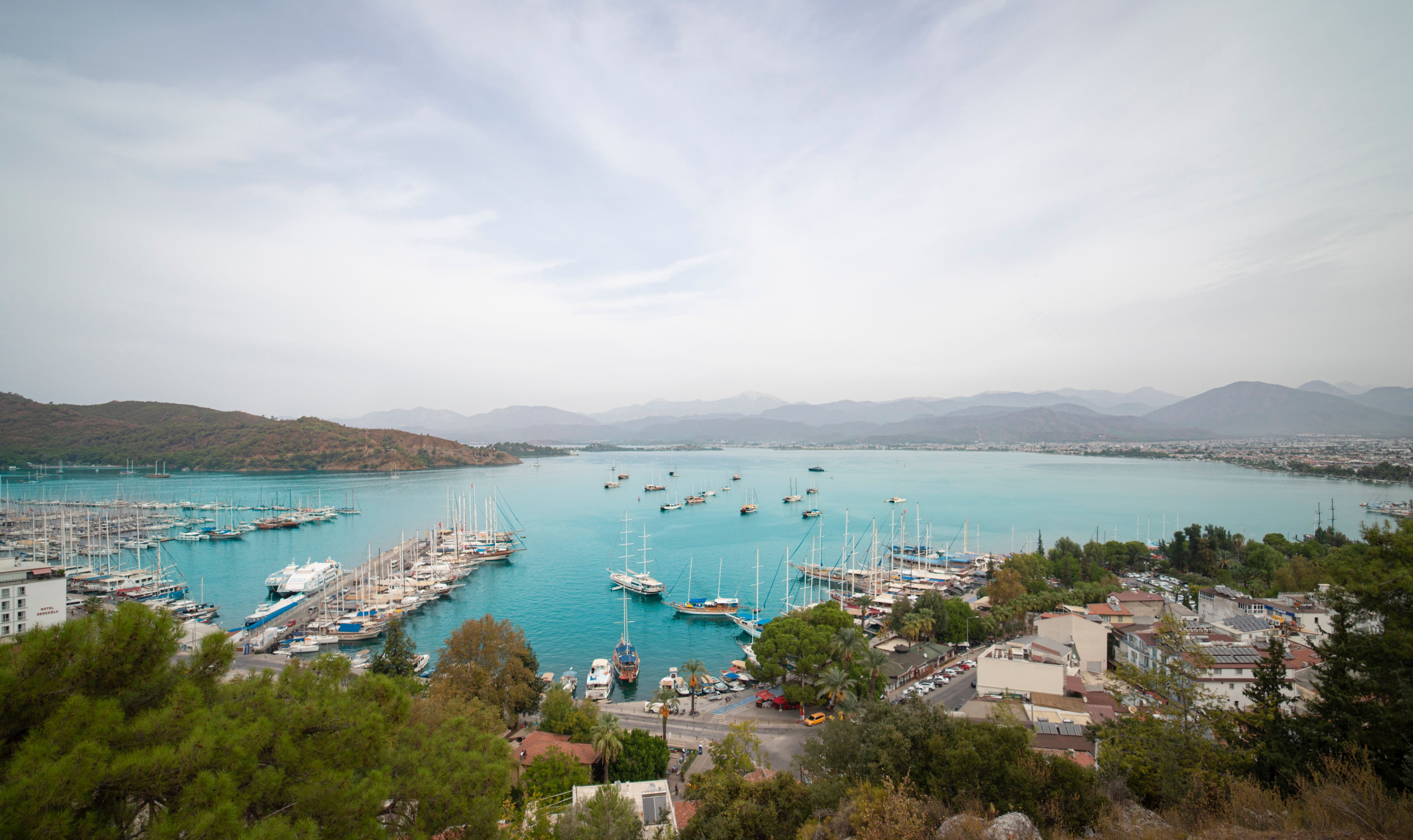 Spectacular Antalya Lara Pirate Boat Trip w/Soft Drinks, Lunch & Pickup Review 2026 - Scenic aerial view of Fethiye marina with yachts and turquoise waters in Turkey.