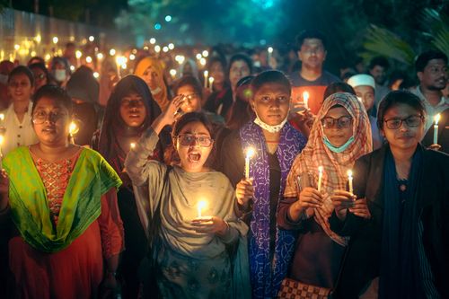 Free A diverse group of people holding candles at a nighttime vigil outdoors. Stock Photo