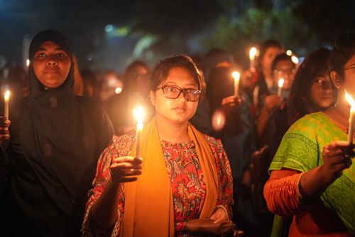 Free A diverse group of people holding candles during a nighttime vigil, conveying unity and peace. Stock Photo