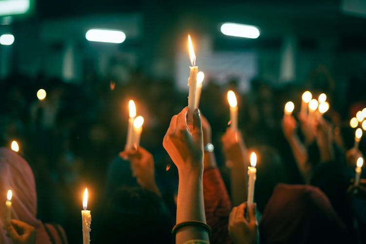 A Group Of People Holding A Lighted Candles