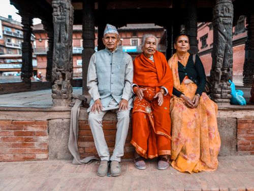 Free Group of elderly Nepali people in traditional clothing sitting in a historic location. Stock Photo