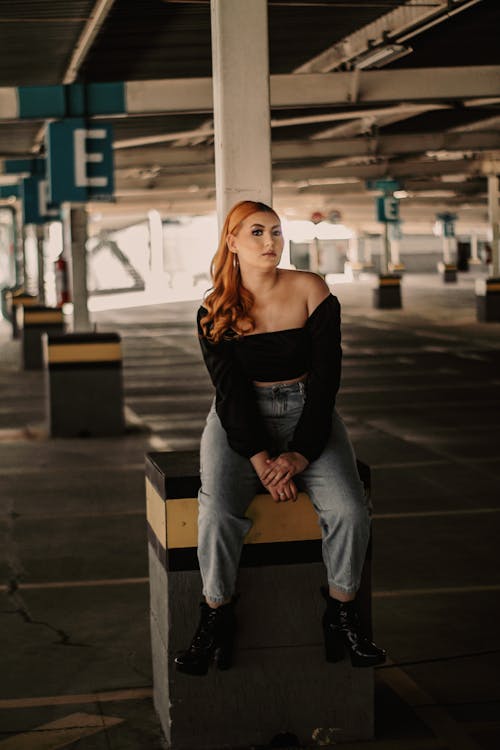 A Woman in Black Long Sleeves and Denim Jeans Inside a Parking lot