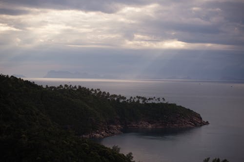 Island on Seacoast during Dusk under Cloudy Sky 