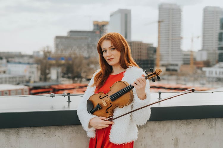 Violinist In Red Dress Standing In Rooftop