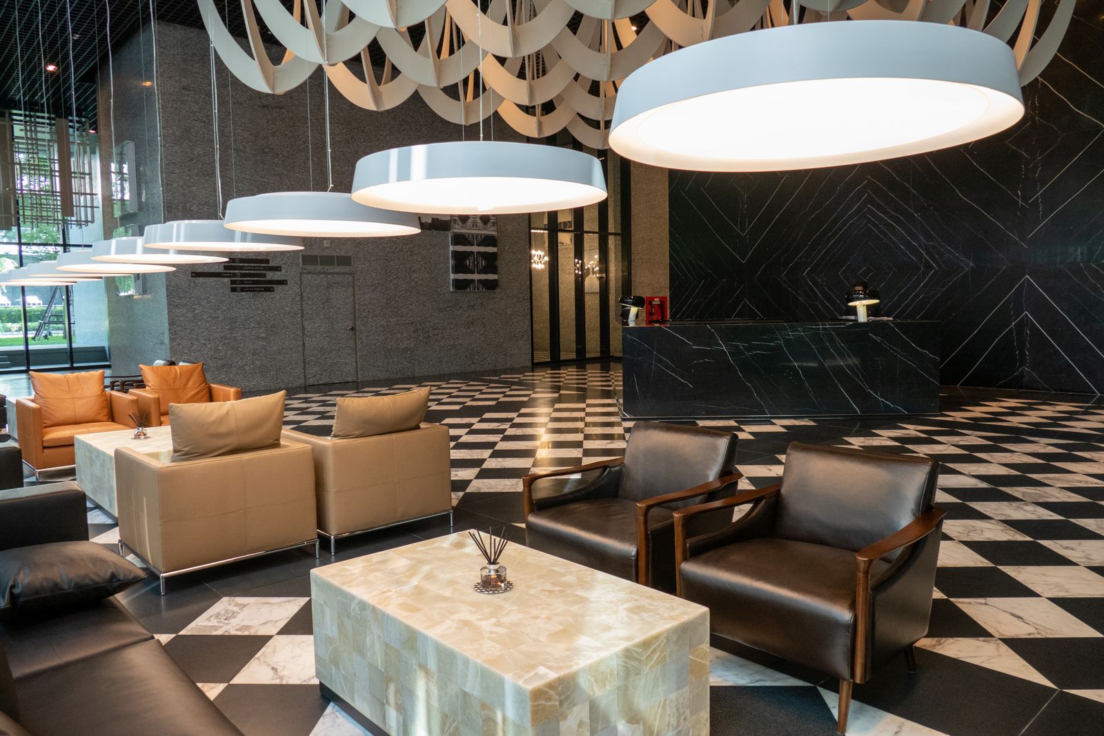 Hall d'hôtel luxe — lobby avec réception, fauteuils cuir et suspensions design