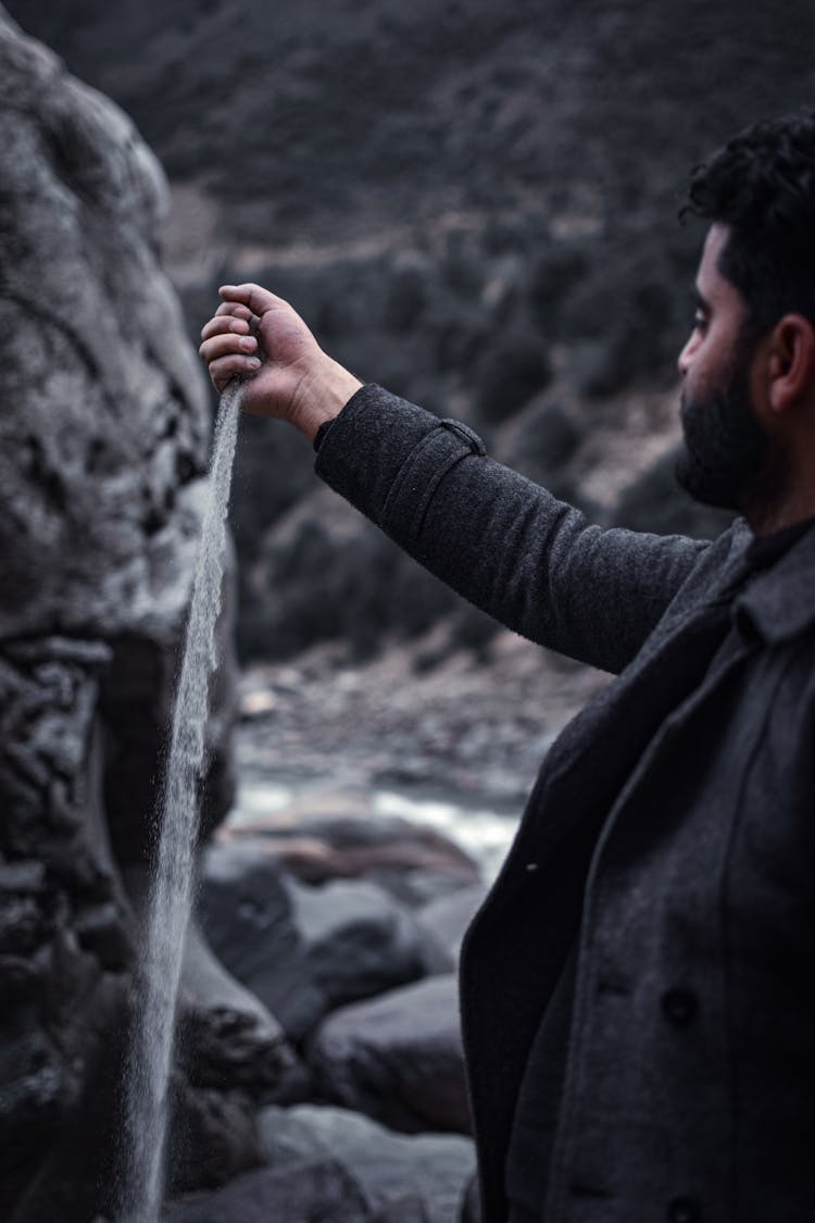 Man Pouring Sand From His Hand 