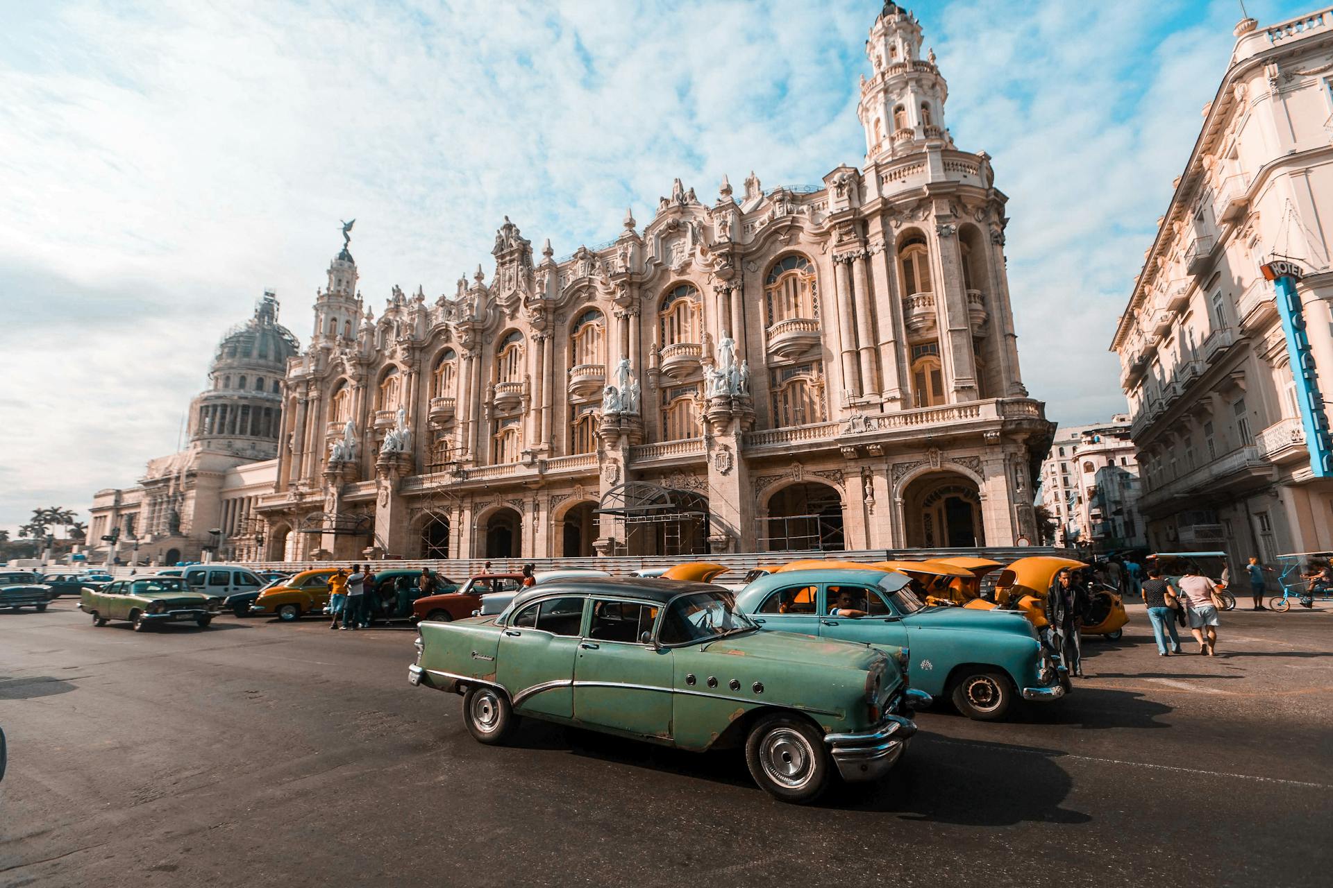 Vintage Cars Parked in Front of Beige Baroque Building in Havana, Cuba