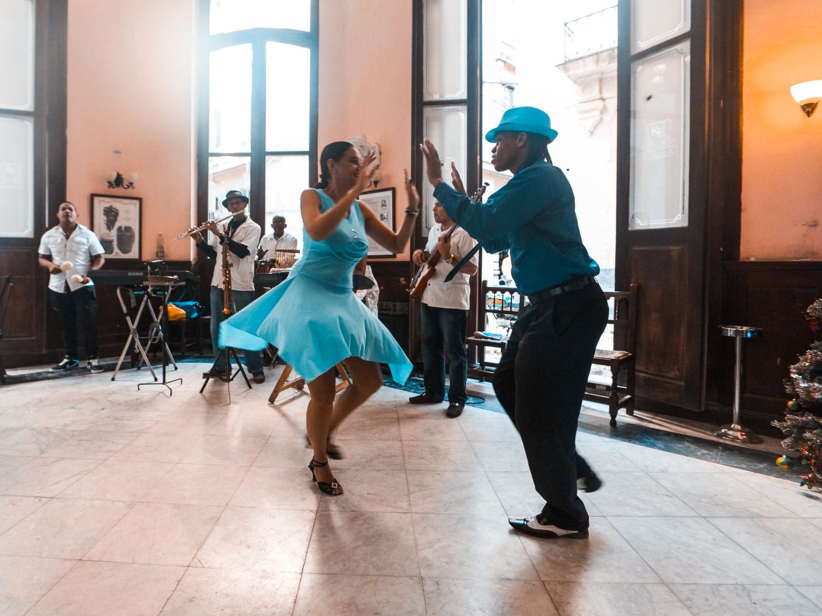 Dancers moving to Latin rhythm in a colorful studio setting