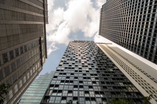 Free Dramatic low angle view of towering skyscrapers against a partly cloudy sky. Stock Photo