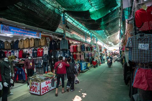 Free Explore a bustling outdoor market with diverse clothing stalls and vibrant atmosphere. Stock Photo