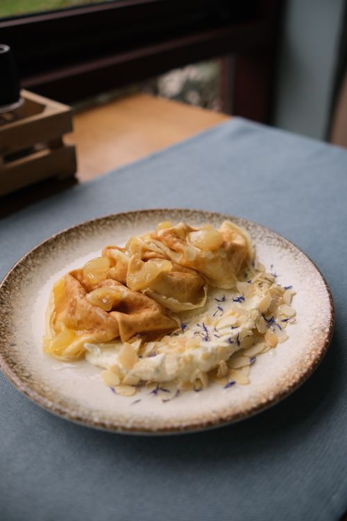 Free Homemade tortellini served with a creamy sauce and floral garnish, perfect for gourmet food lovers. Stock Photo