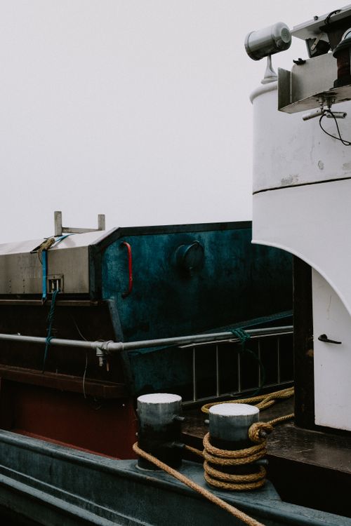 Free A detailed view of a docked boat showing ropes and cleats on a calm day. Stock Photo