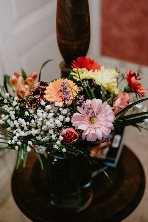 Free Colorful floral bouquet with daisies and roses in a rustic vase indoors. Stock Photo