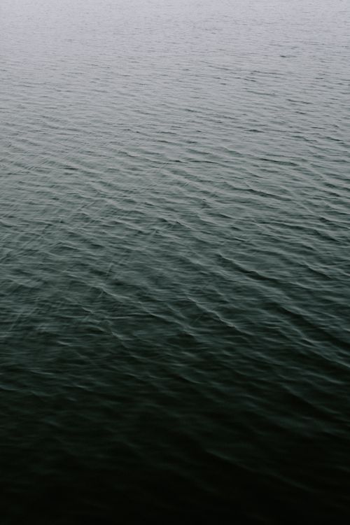 Free Calm sea surface with gentle waves creating a tranquil atmosphere during the day. Stock Photo