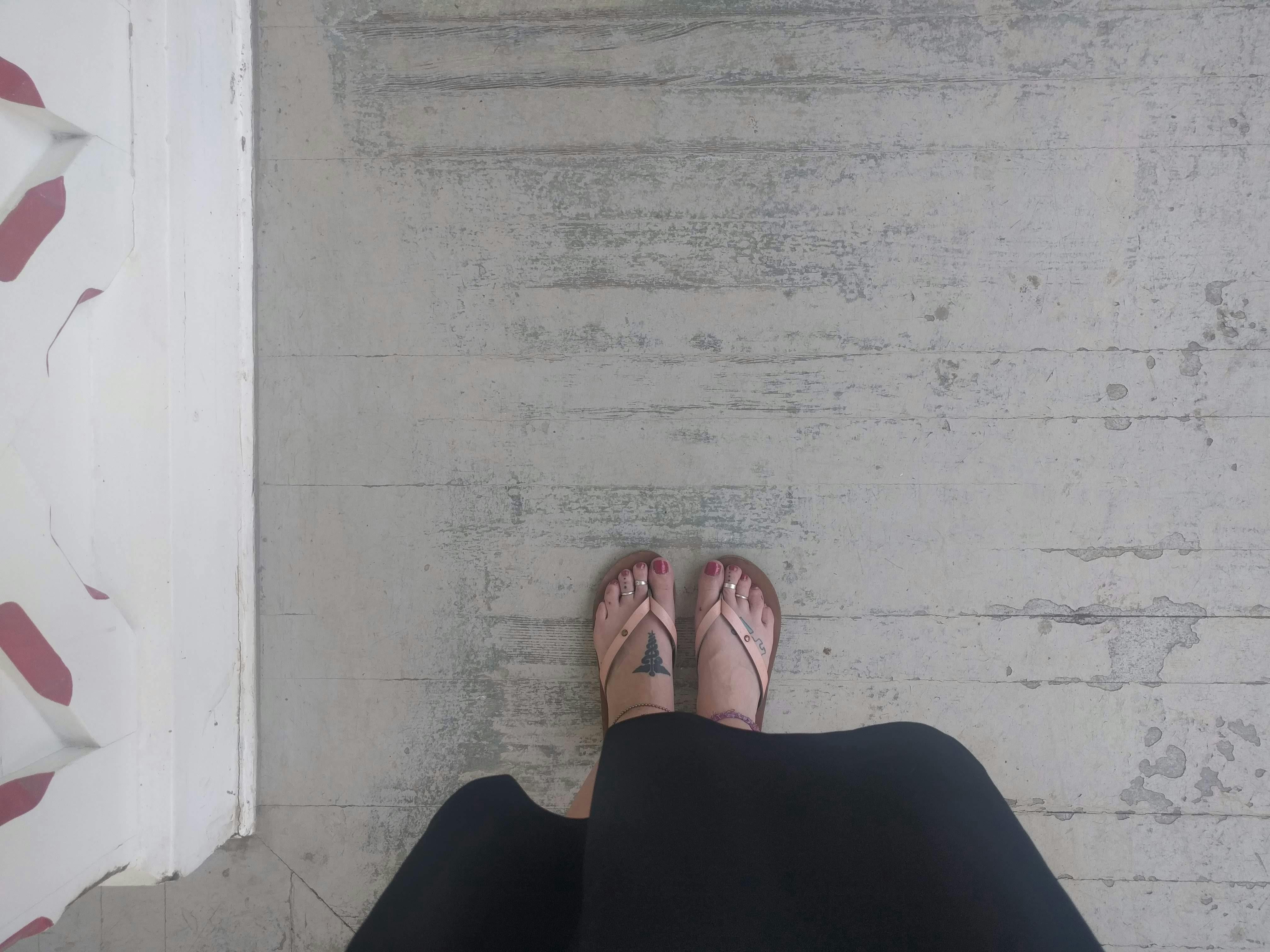 Free stock photo of Feet on wood floor by railing
