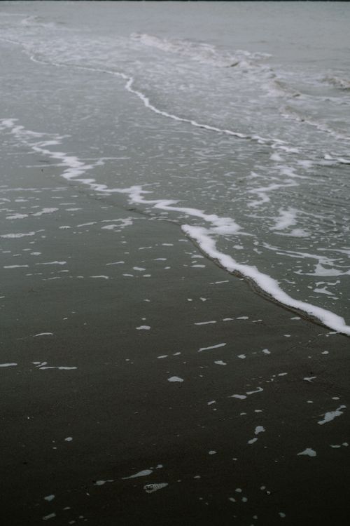 Free Serene ocean waves gently reaching the sandy shoreline, creating a peaceful and tranquil scene. Stock Photo
