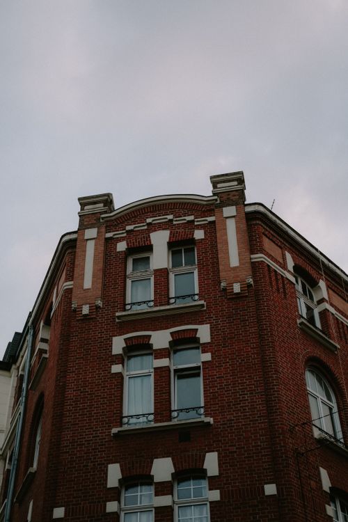 Free Low angle view of a classic brick building facade with architectural details at dusk. Stock Photo